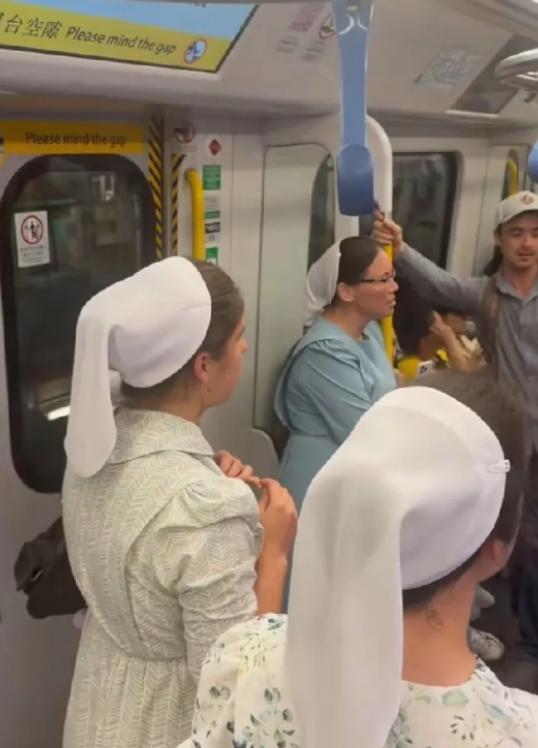 5月7日，一群戴白头巾的外国人在香港地铁大声唱歌，热情好客的香港人安静欣赏，没有