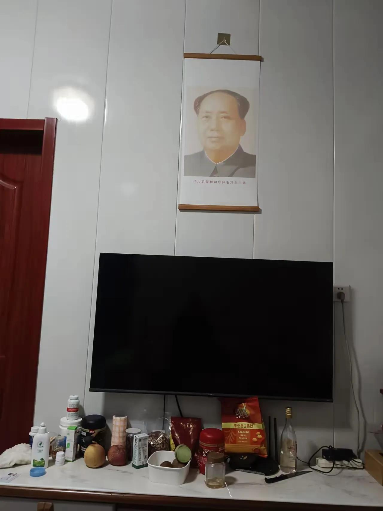 我家客厅挂着一幅毛主席像。同事来吃饭他看了一眼，随口说：“你家装修这么洋气，挂这