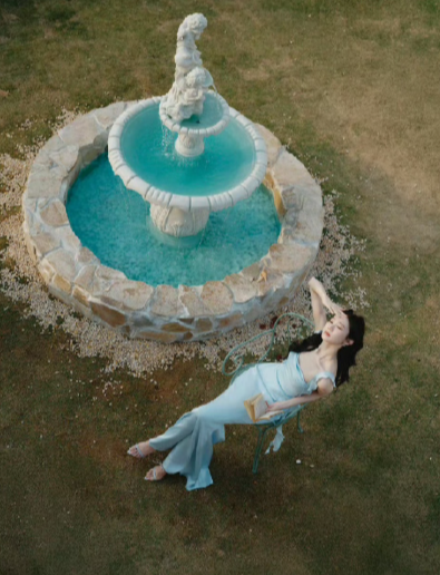 张艺凡身着的雾霾蓝吊带纱裙通过波浪裙摆、高腰剪裁和珍珠刺绣设计，精准勾勒其腰臀曲