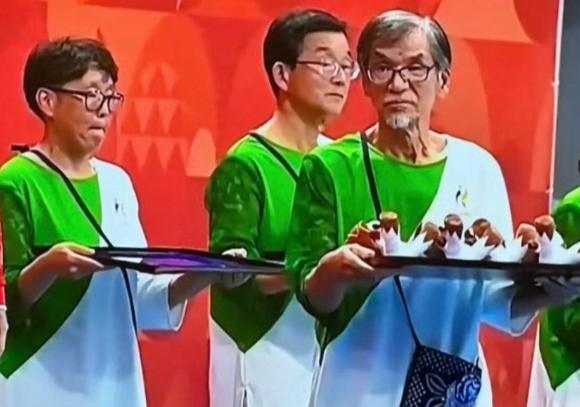 我们全错怪日本组委会了！放着年轻礼宾姐姐不用，偏偏清一色大爷上岗，根本不是招不到