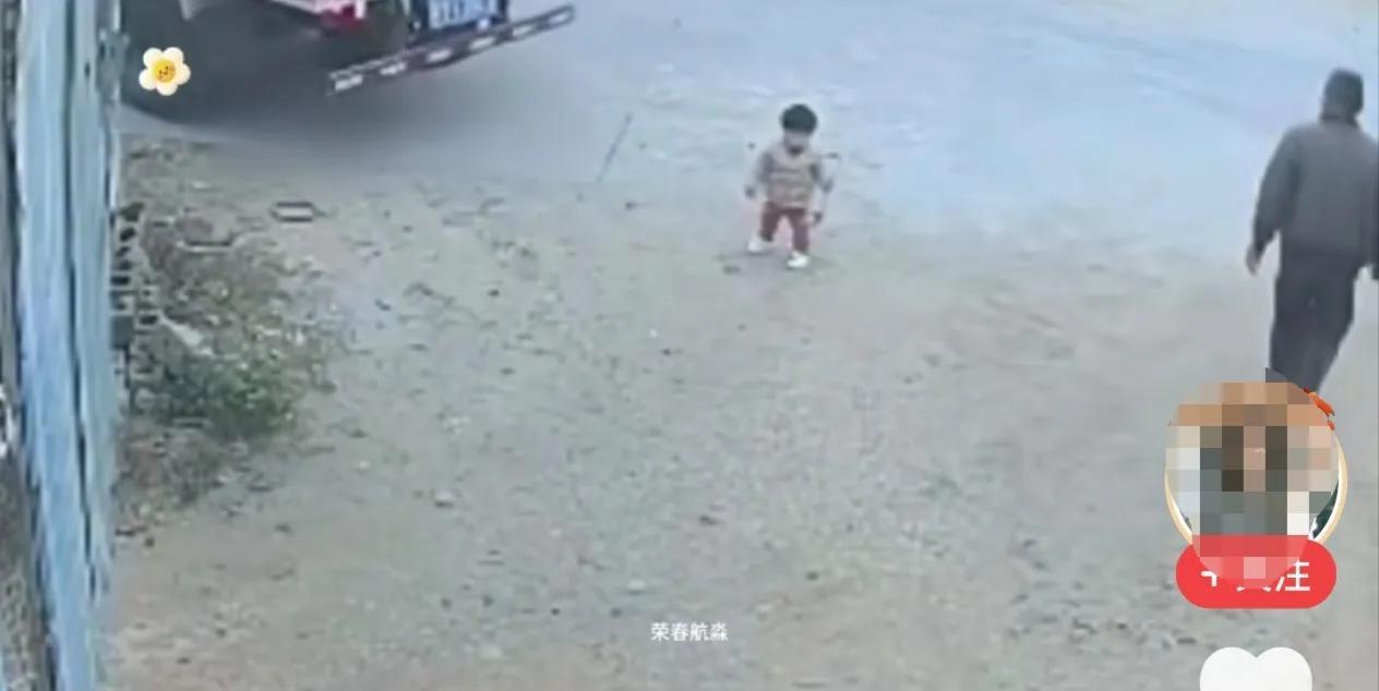 在农村一个小加工厂大门口的路边，一名两三岁的小女孩站在路边玩耍，这时从加工厂里走