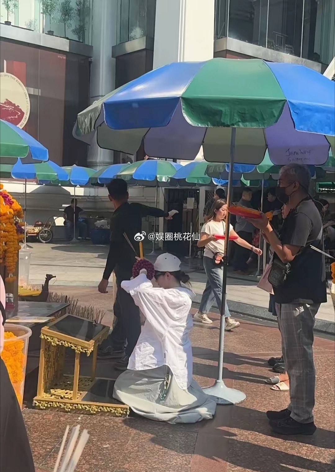 戚薇现身曼谷拜四面佛，李承铉现身陪同。戴着棒球帽的她，穿着白色衬衣配灰色宽松裙裤