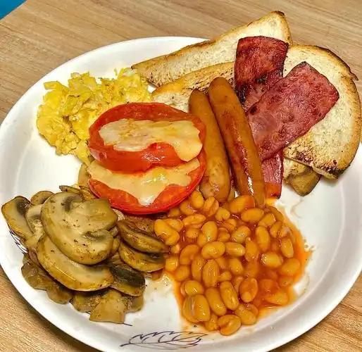 提到全套英式早餐，培根煎蛋、香肠是大家最熟悉的标配，而餐盘角落那一小碗橙红透亮的