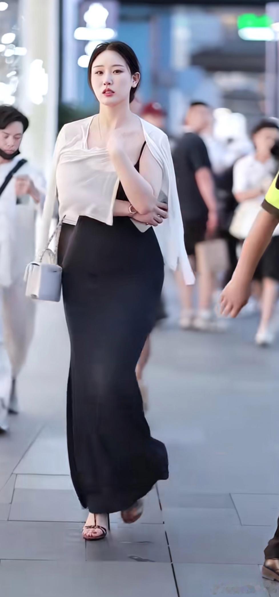《街头这套黑白搭配真的很耐看，修身黑色吊带长裙，配上一件轻薄白开衫，温柔又大气，成熟风穿搭可以参考。