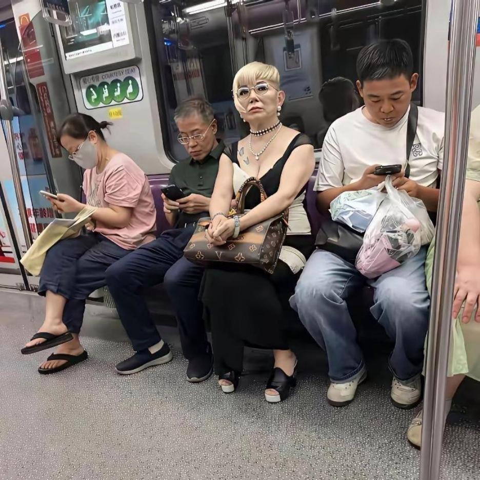 地铁里一眼就被这位大姨吸引住了！一车厢的乘客都在低头玩手机，唯独中间这位大