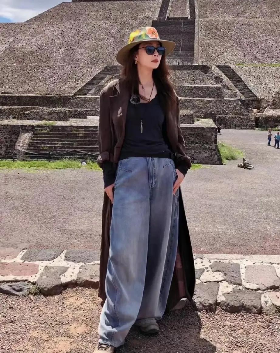 谁被殷桃这组旅行图惊艳到了？复古长风衣搭配阔腿牛仔裤，宽檐帽点缀，随性又大气。
