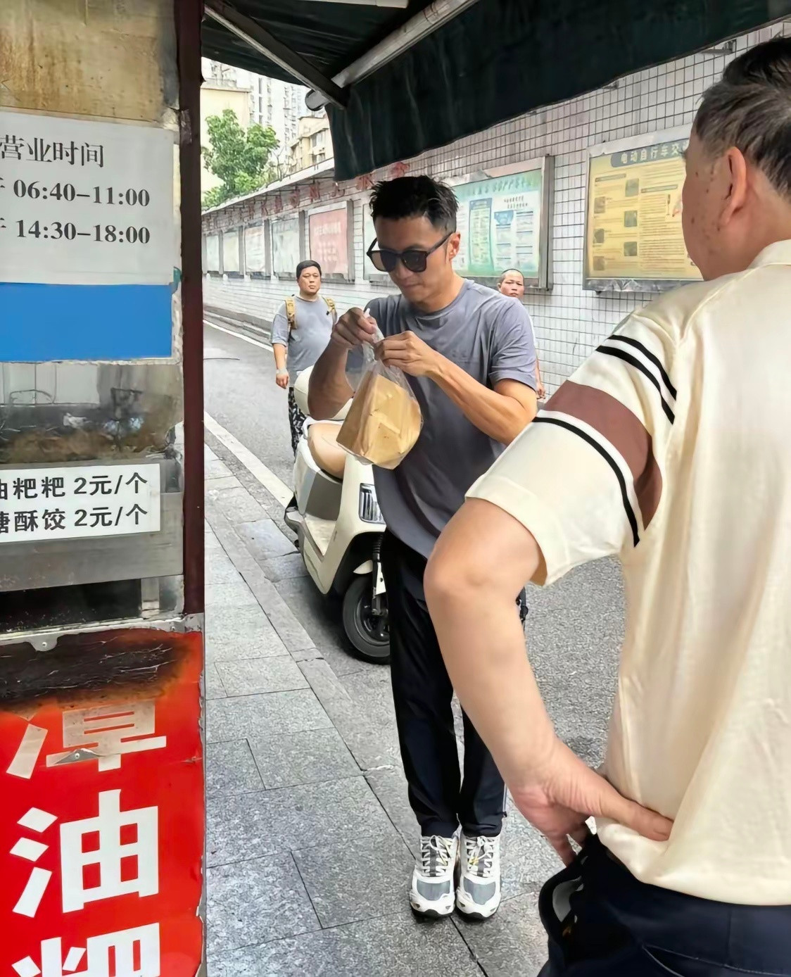 谢霆锋在湖南长沙小巷子里的路边摊买葱油粑粑，他现实中真人看起来很帅气，穿衣打扮有