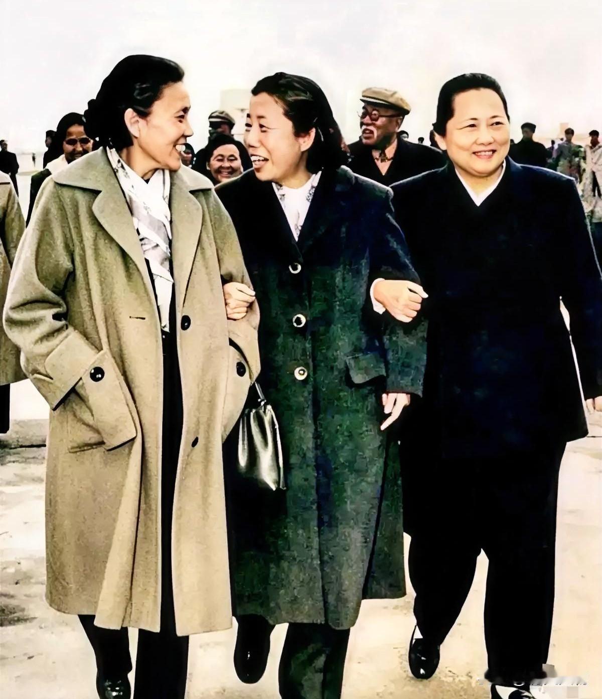 蔡畅、邓颖超、宋庆龄手臂相挽，并肩缓步前行。三位伟大的女性边走边轻声谈笑，神态从