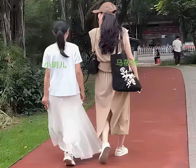 马筱梅带小玥儿逛公园，小玥儿身穿长裙，看着自信满满的样子，与马筱梅相处的很融洽，