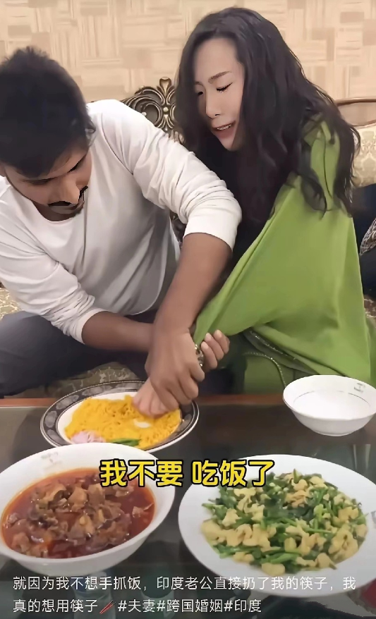 中国女子嫁到印度，丈夫正在努力教她用手抓饭吃，看得出丈夫教得很认真，女子学得很痛