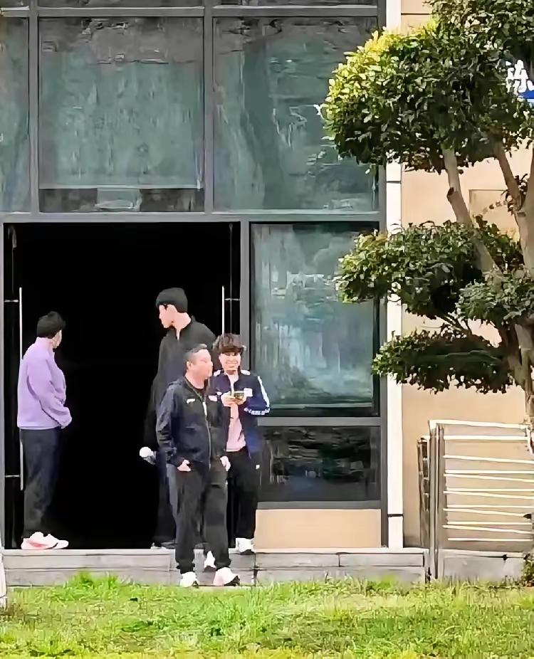 可爱的大迪拿起手机向河对岸拍摄！国乒成都封训两天了，不但有爬上树拍摄国乒运动员