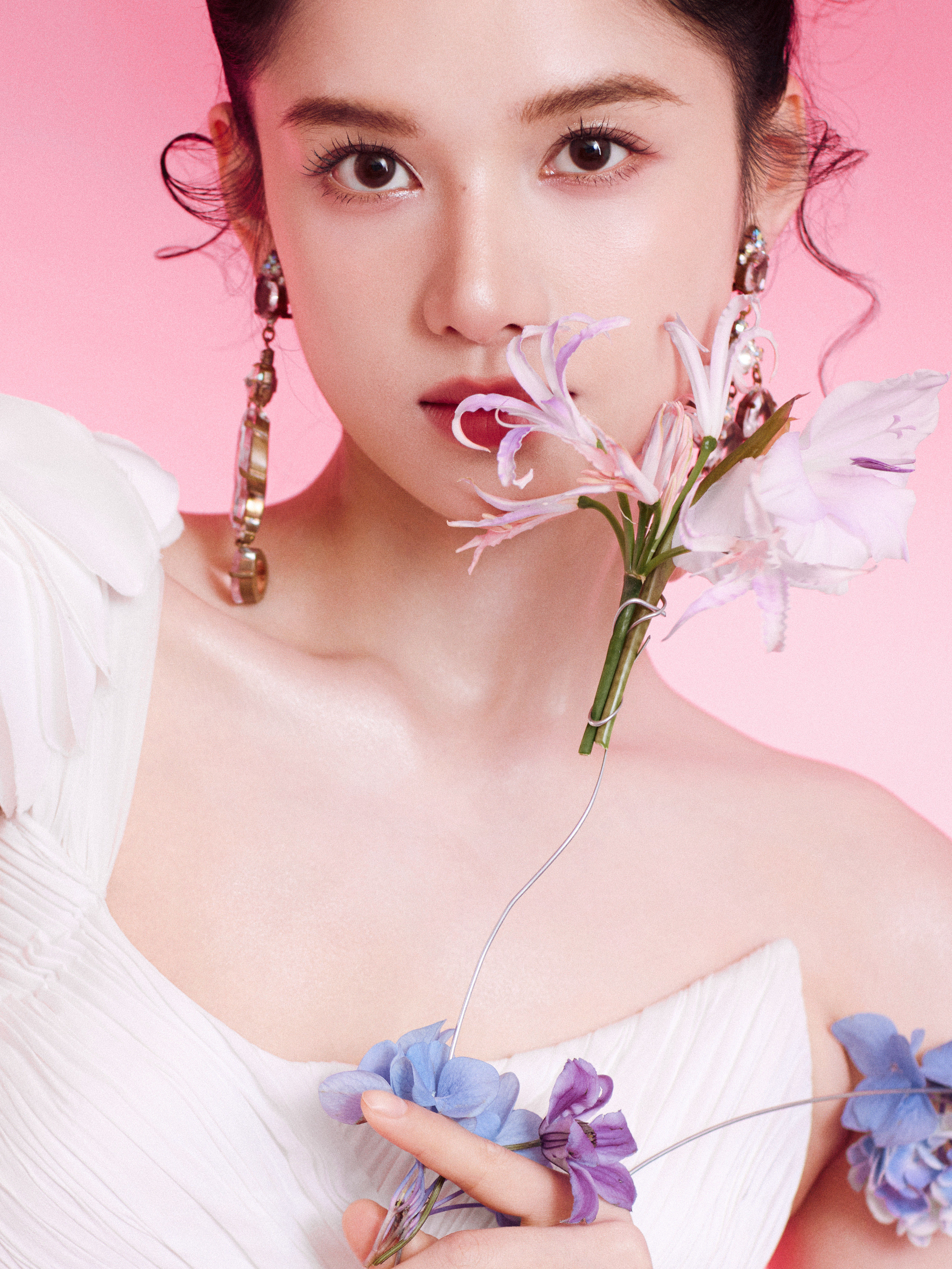 当柔粉撞进纯白褶皱，张婧仪是从春日梦境走出的诗篇。单肩花饰垂落星光，曳地裙摆漫过