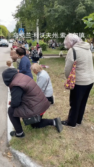 乌克兰民众在马路边跪地迎接在战场上牺牲的烈士们回家！他们都是为保卫国家而英勇战