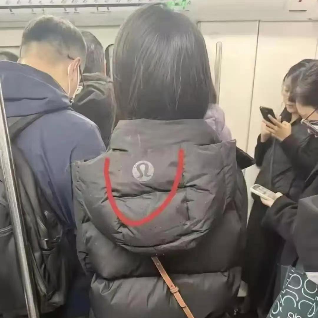 地铁撞见一件羽绒服，第一眼我看错了！坐地铁偶遇一位小姐姐，后背羽绒服图案，