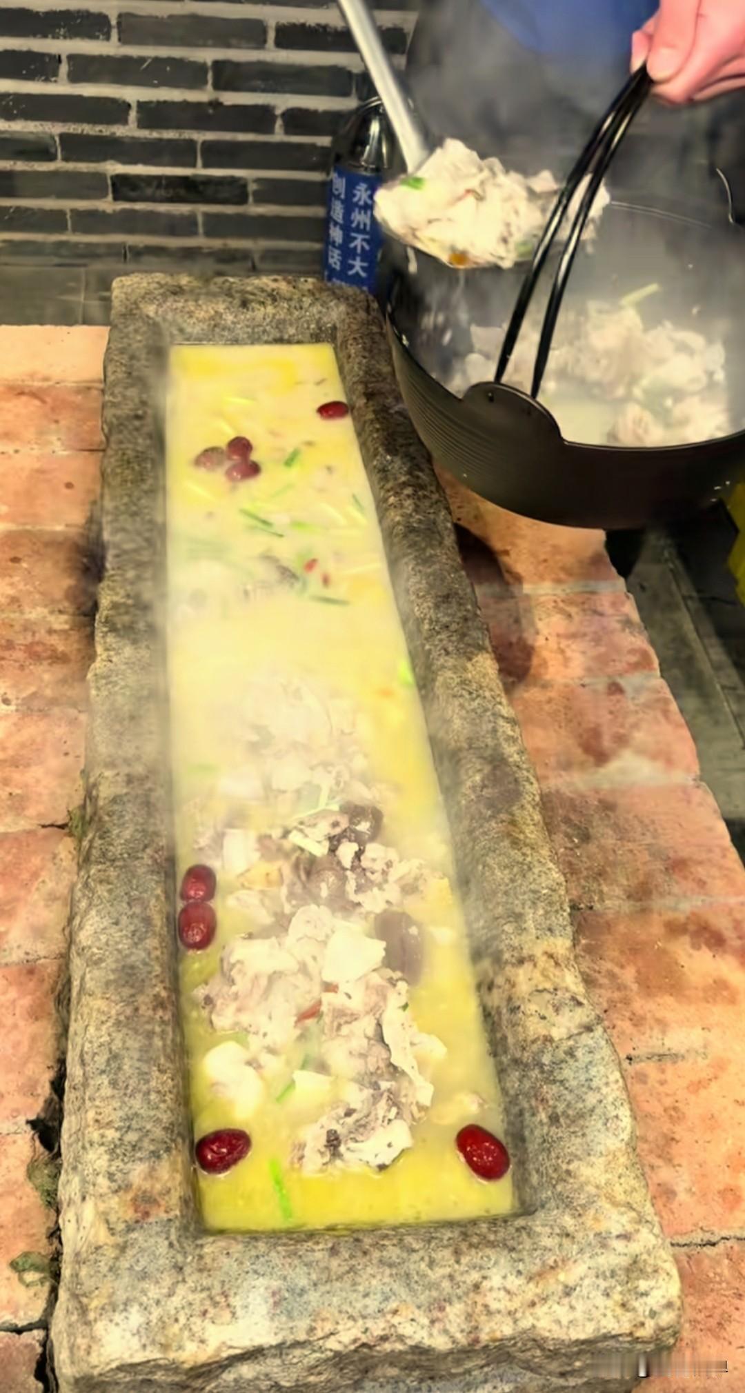 湖南永州一饭店上新“石槽火锅”，被网友调侃神似“猪食槽”。这种火锅以传统农家