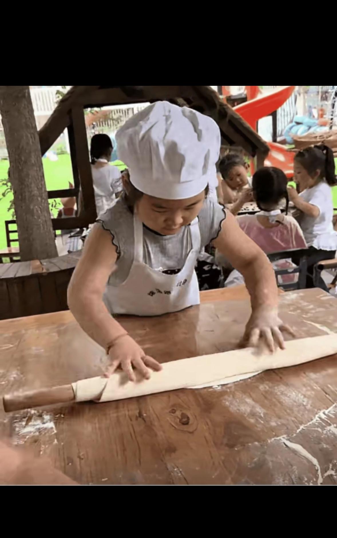 家长：今天我家娃上幼儿园哭了吗？老师：没时间哭，忙着颠勺呢~三岁的小胖子系着