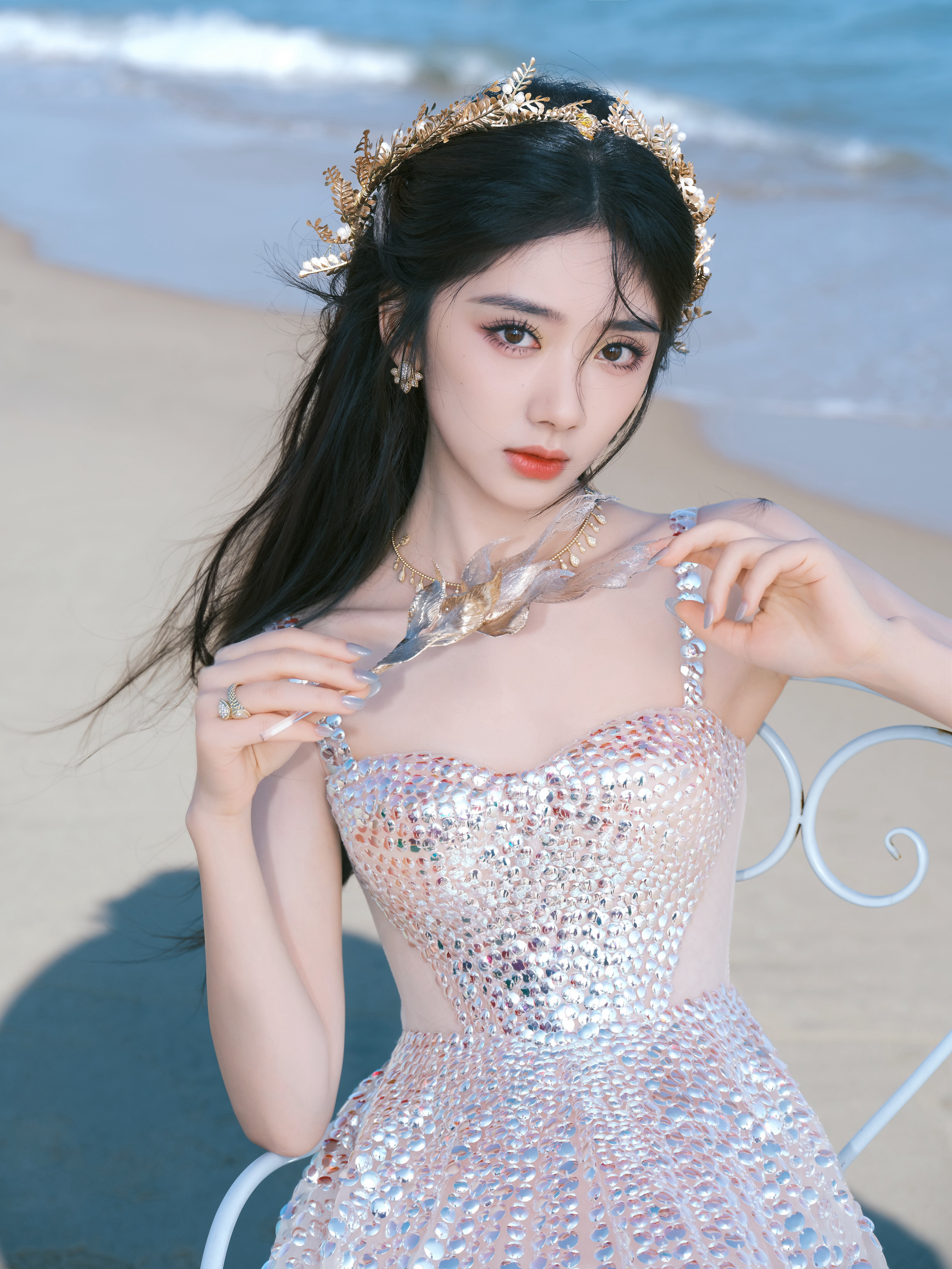 王影璐海浪轻吻沙滩，碎钻裙摆揉进了海的粼光，手持花束的瞬间，像把整片海洋的浪