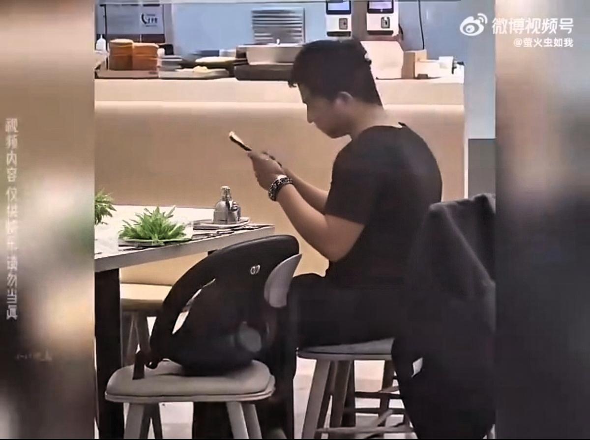 吉林财经大学一男生抱花在食堂等候表白，女方未现身且线上拒绝。他久坐刷手机后情绪失