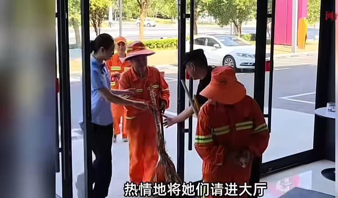 “这个银行火了！”湖北武汉，环卫工人站在银行门外，踮着脚看银行大厅屏幕上播放的