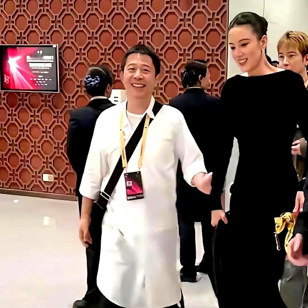 宋佳二封影后风光无限，台下和男友牵手互动。他男友穿着一身白衬衫裙，就站在高跟鞋