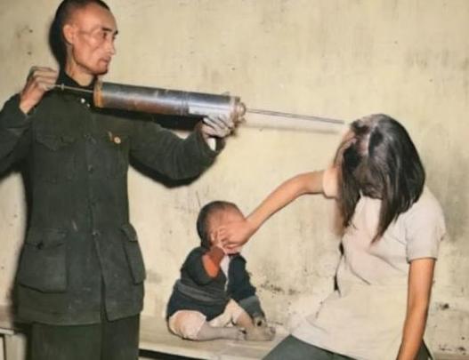 50年代，一名男子拿出一个“大针管”，对着一名女子的头部，喷出白色的粉末。女子赶