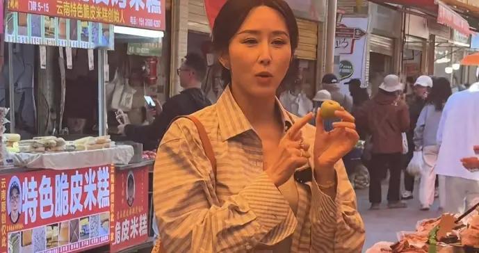 胡静接地气现身农贸市场！朴素打扮买年货，边吃米糕边聊天