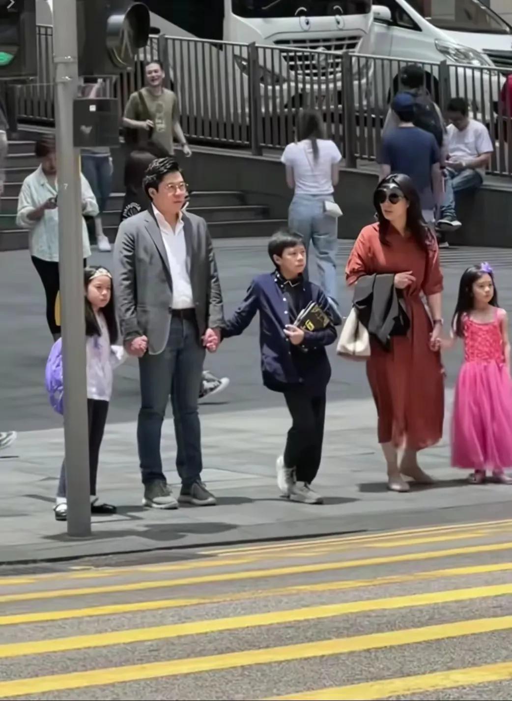 5月5日香港街头，霍启刚郭晶晶一家五口手牵手等红灯，无保镖随行，孩子乖巧独立，尽