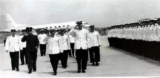 1950年3月，青岛海边，一位身着军装的中年男子正站在码头上，眉头紧锁地望着眼前