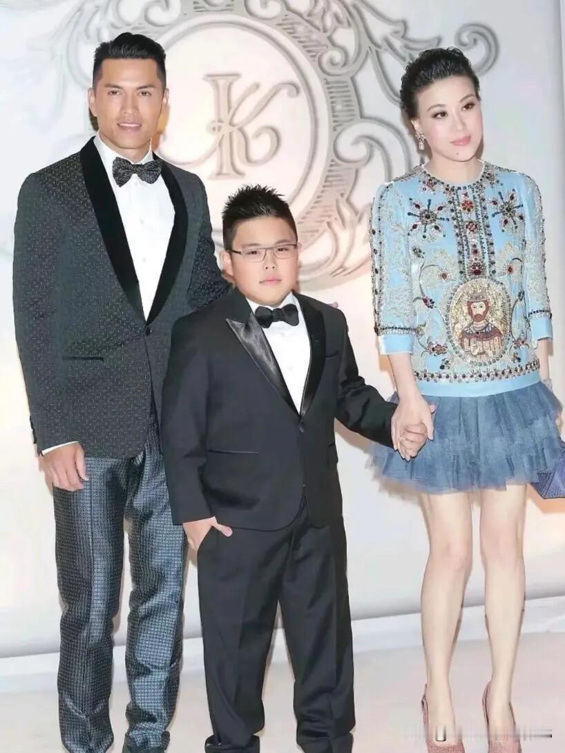 吕良伟穿着西装，帅气英俊，是身材比例匀称完美的男神，他的妻子杨小娟皮肤白皙，不胖