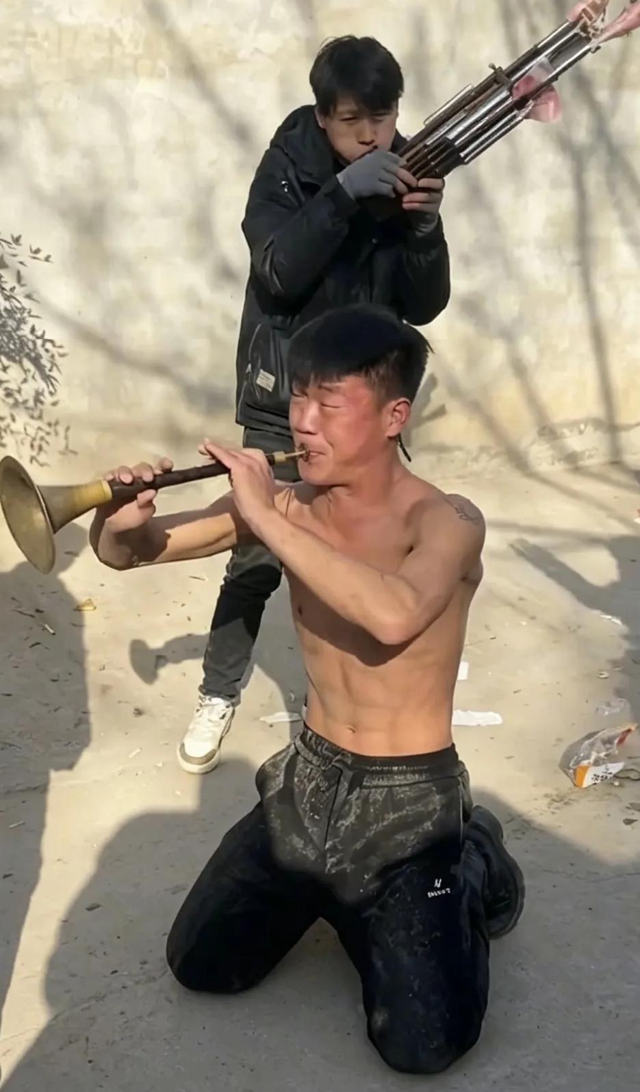 河南周口25岁唢呐手阿豪以吹白事唢呐为生，在一个送灵现场，他跪地对着主人吹了一半