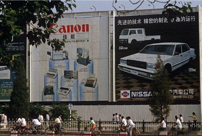 1985年的北京街头的巨型广告牌左侧（佳能Canon）：展示了当时代表先进办公