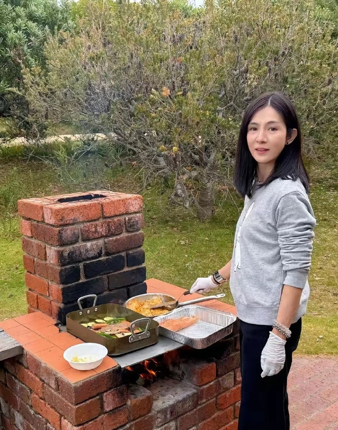 51岁杨采妮和老公以及一对双胞胎儿子在新加坡的家里户外烧烤，她的状态真好，外表很