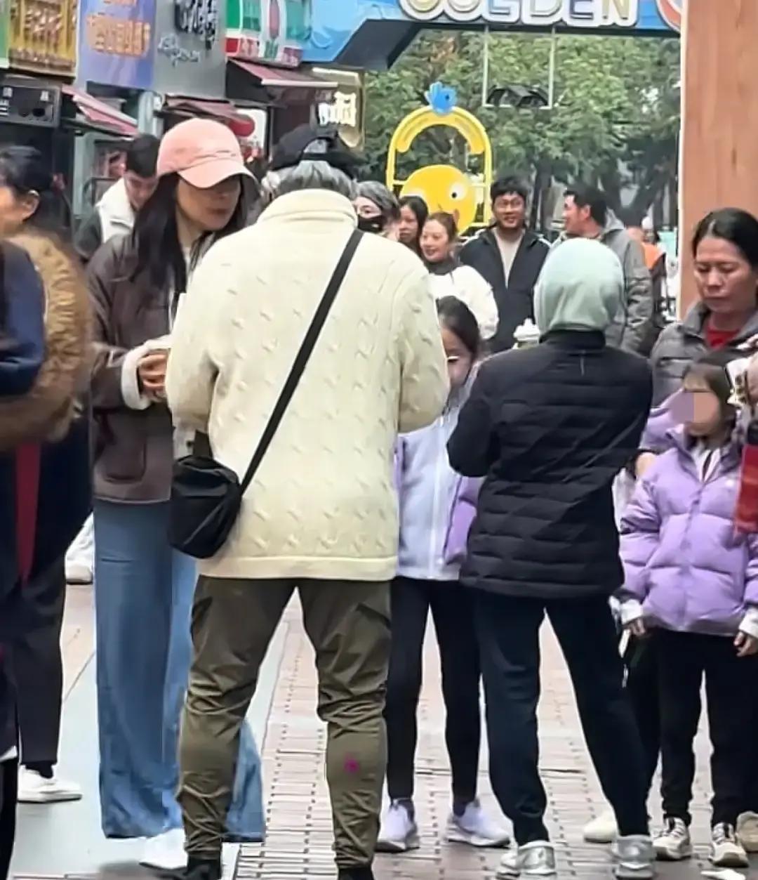79岁霍震霆拎9块奶茶排队广州南沙商场里，网友拍到霍震霆穿旧毛衣戴棒球帽，