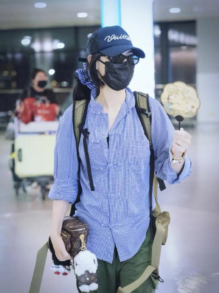 张柏芝机场私服真时髦！穿蓝格衬衫+军绿工装裤+棒球帽，休闲随性又减龄！