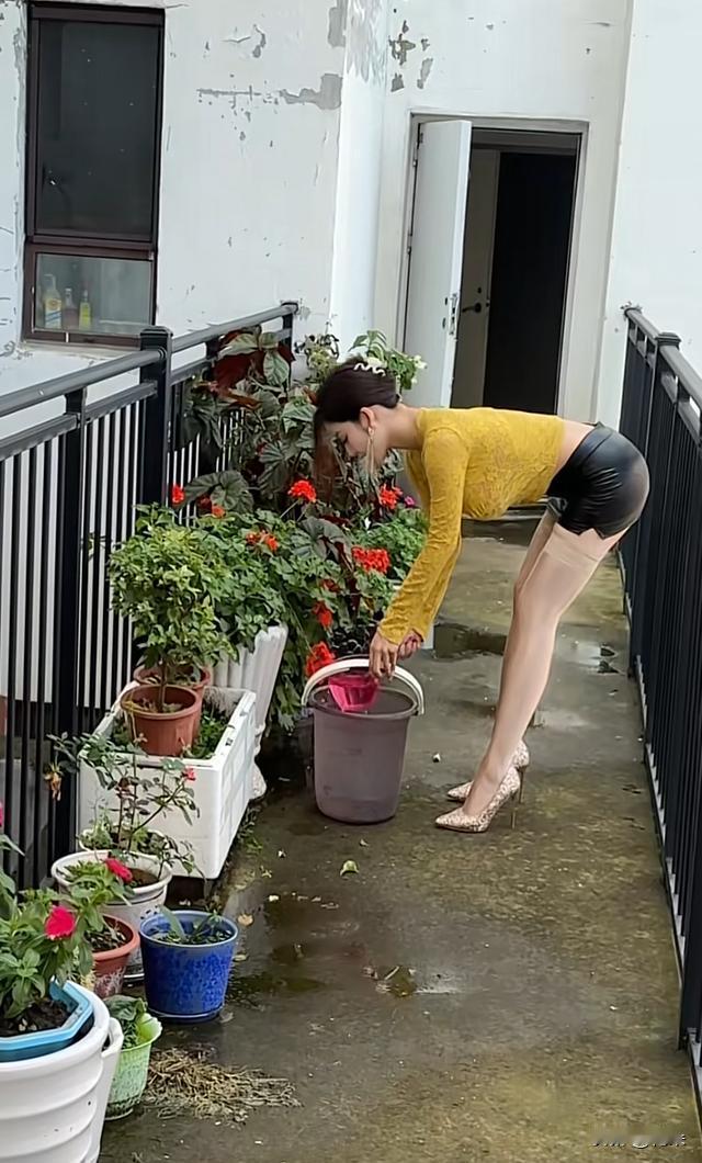 美女阳台上每天早上浇花，人美花美我心情美