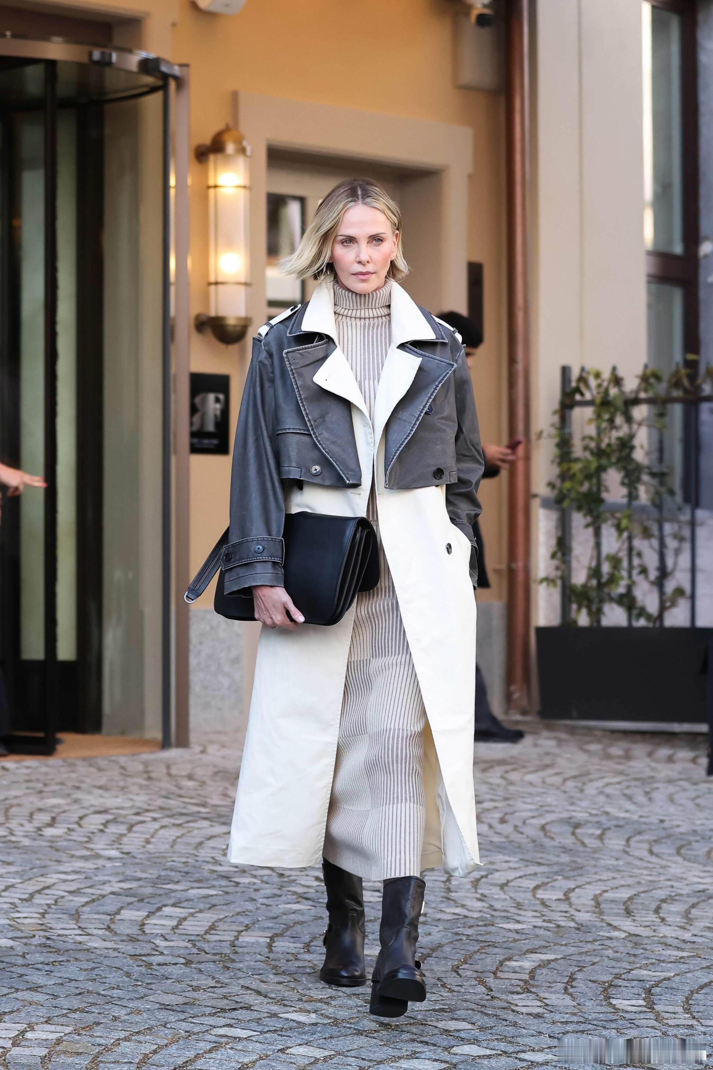 charlilzetheron查理兹塞隆在米兰外出离开酒店，塞妈长款大衣搭配短