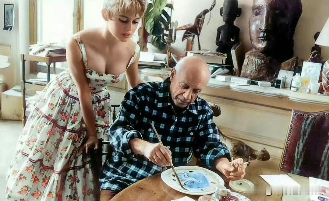 1956年，法国戛纳电影节期间，74岁的毕加索正潜心创作，身旁伫立着21岁、被称