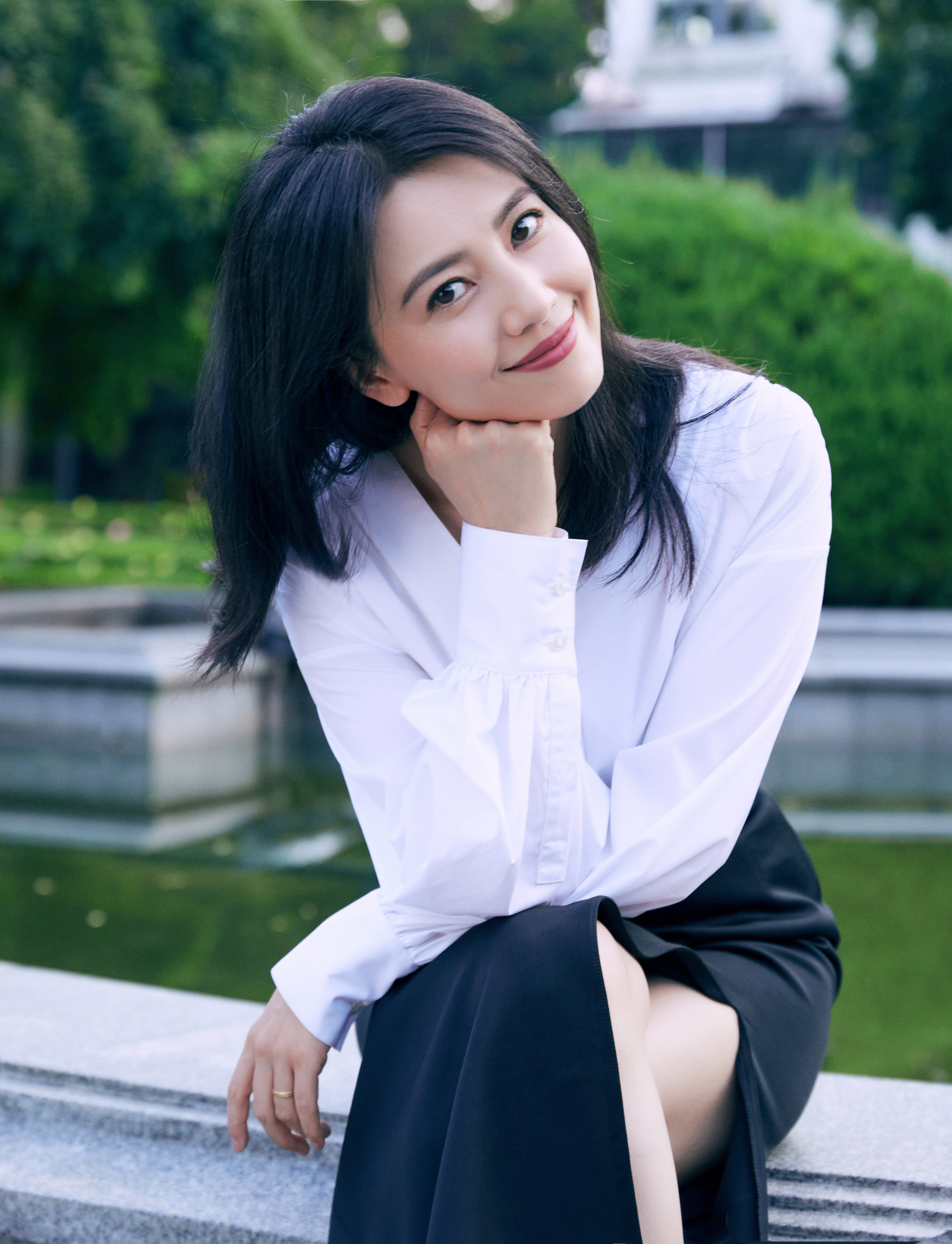 气质依旧清新动人。白衬衫与黑裙的经典搭配，简约又不失优雅，勾勒出利落的线条。她侧