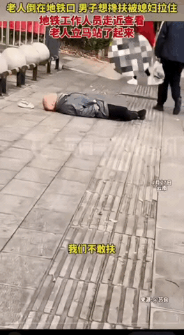 云南昆明，一老人躺在地铁口一动不动，路过一男子想上前搀扶，同行妻子一把将他拉住，