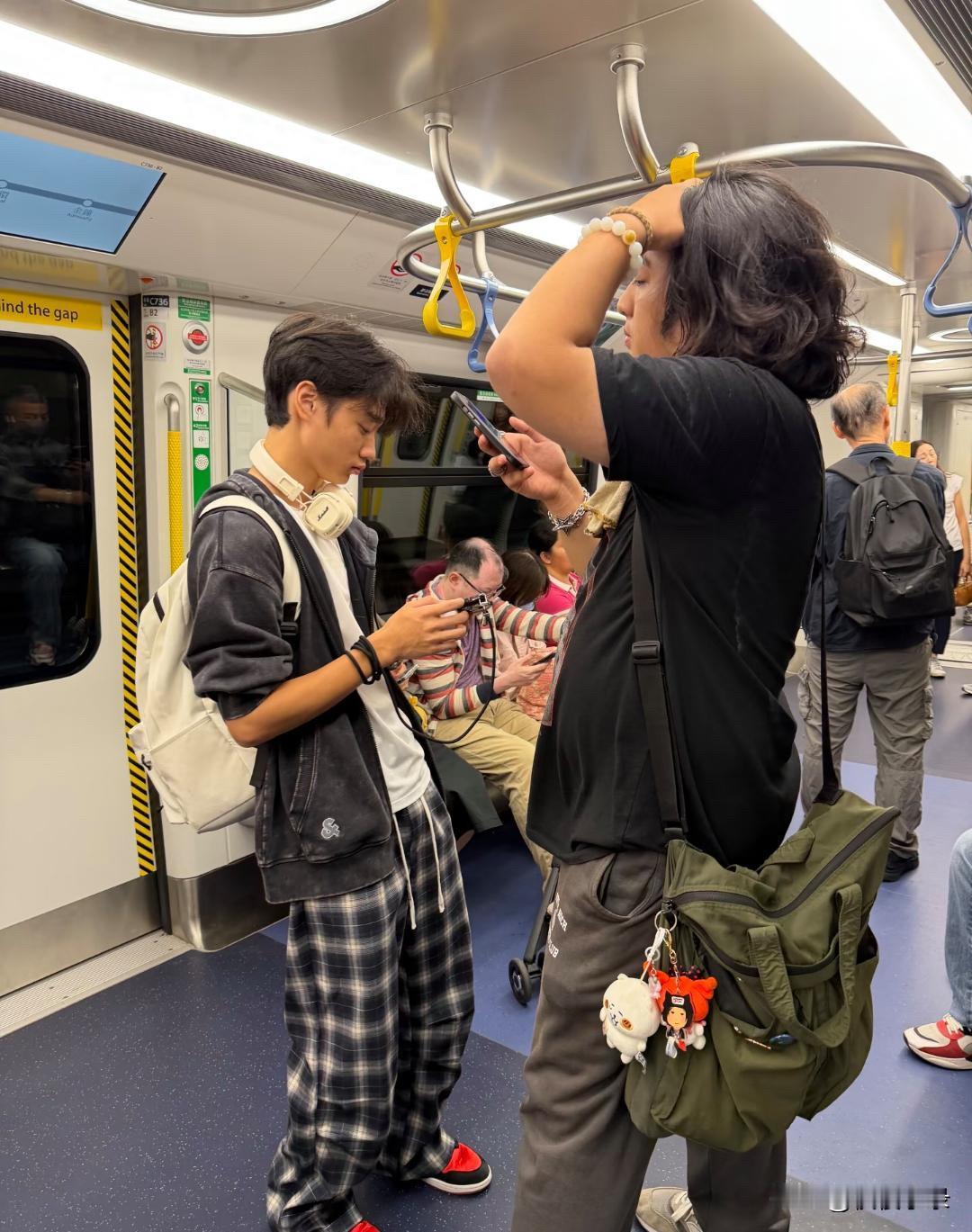 吴镇宇17岁儿子费曼和朋友在香港坐地铁出行，他的穿衣打扮一言难尽，给人一种邋里邋