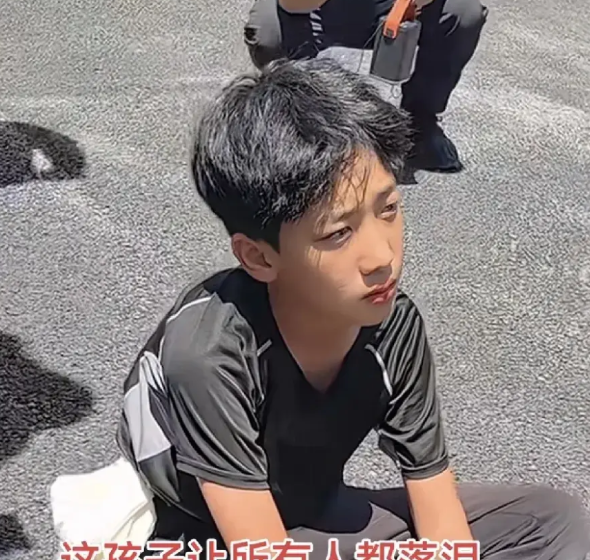 河北邯郸遇难卡友范刚的儿子一动不动地坐在地上看着父亲的遗像，脸上没有一滴眼泪，
