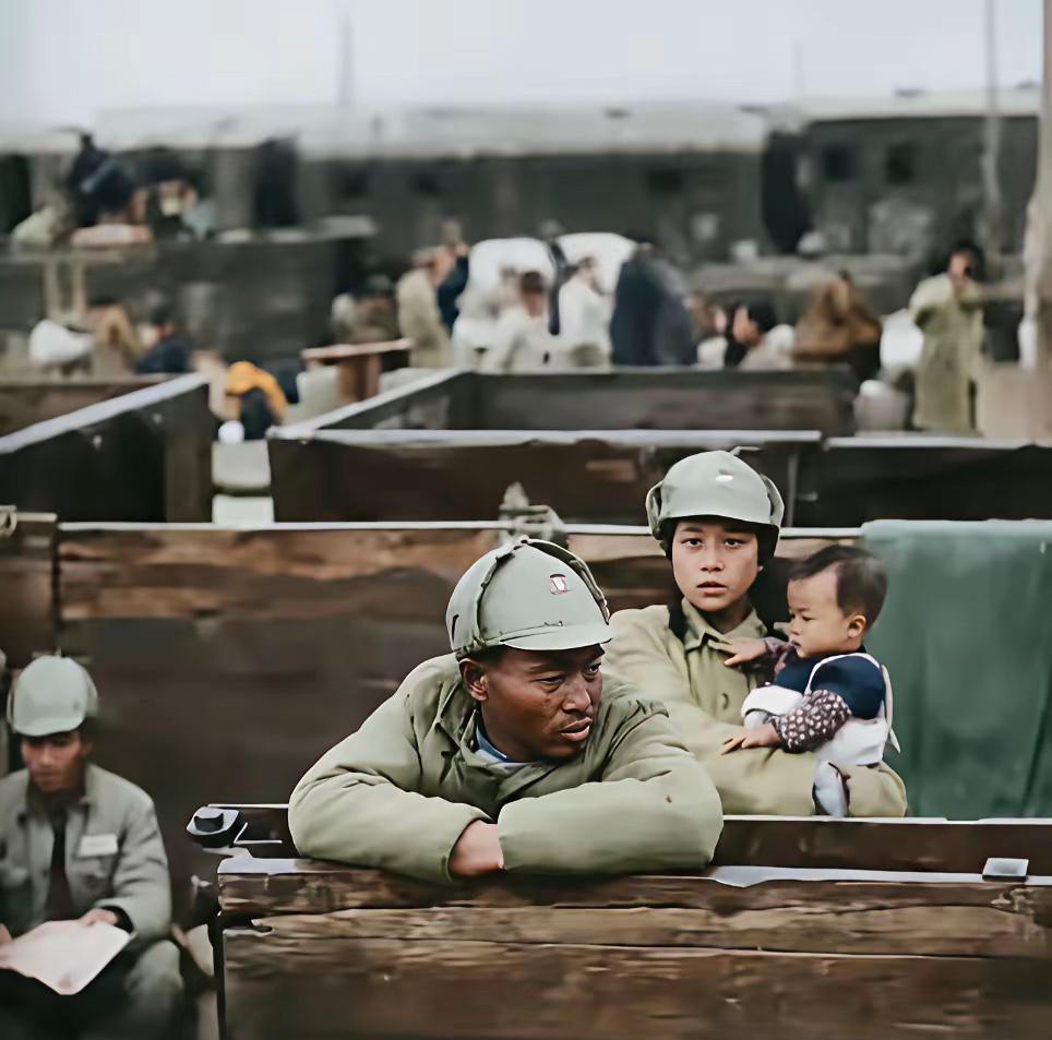 1949年上海码头，一名国军士兵，带着妻儿准备登船前往台湾。丈夫神情沮丧，妻子怀