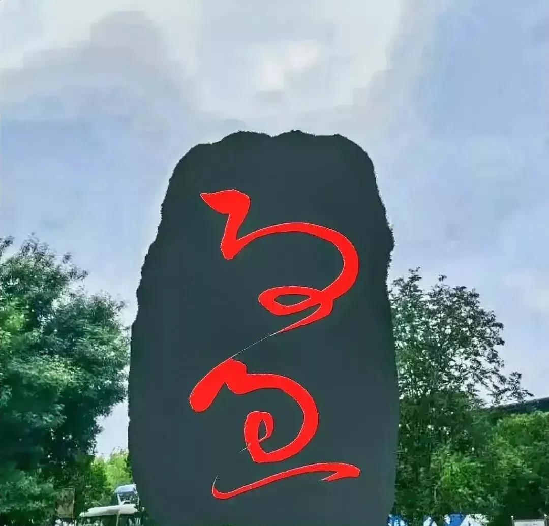 青石碑上刻有两个红色大字，盯了半天没有认出一个，问了不少书法爱好者大家一致认为是