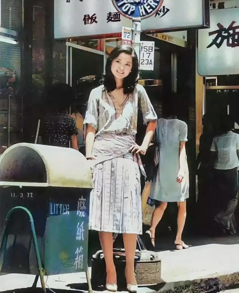 1973年的台北街头，一位年轻美丽的姑娘站在垃圾桶旁边的一张照片。照片中的姑娘