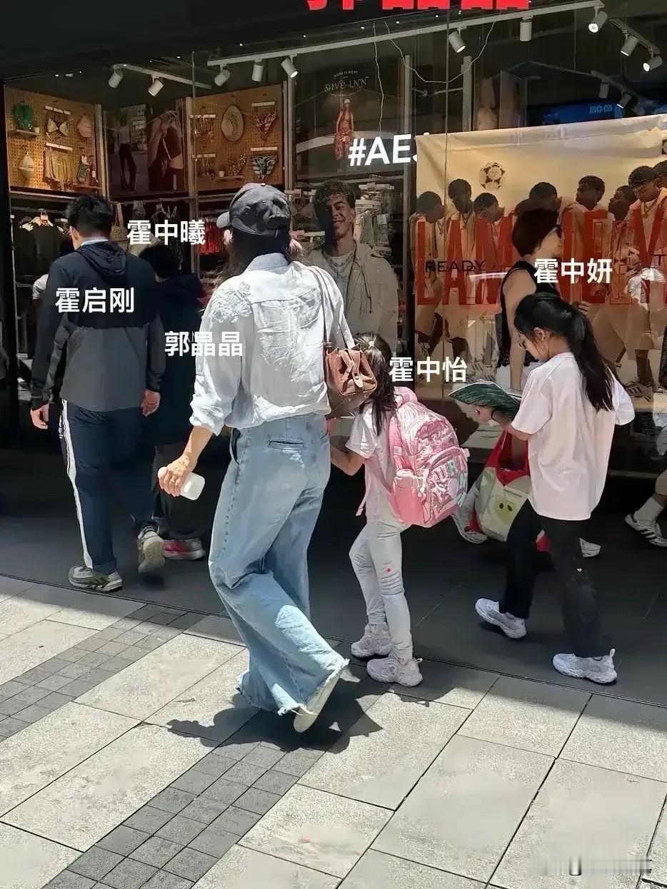 有网友在香港街头偶遇霍启刚与郭晶晶带着三个孩子出行。郭晶晶身穿休闲装，全程牵着小