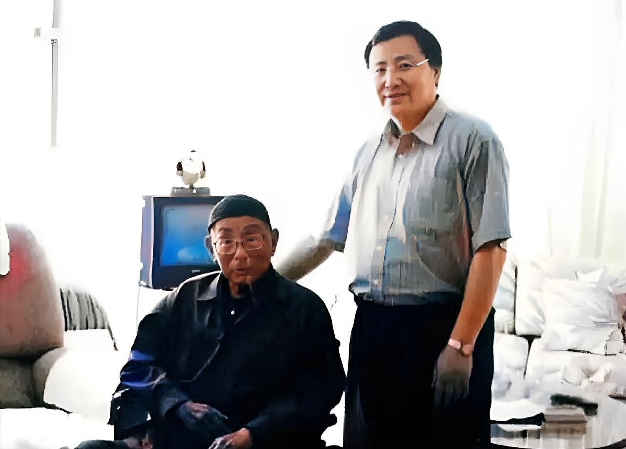 这是2001年百岁的张汉卿与一位戴着眼镜的儒雅男子在一起。很少人知道这位男子的身