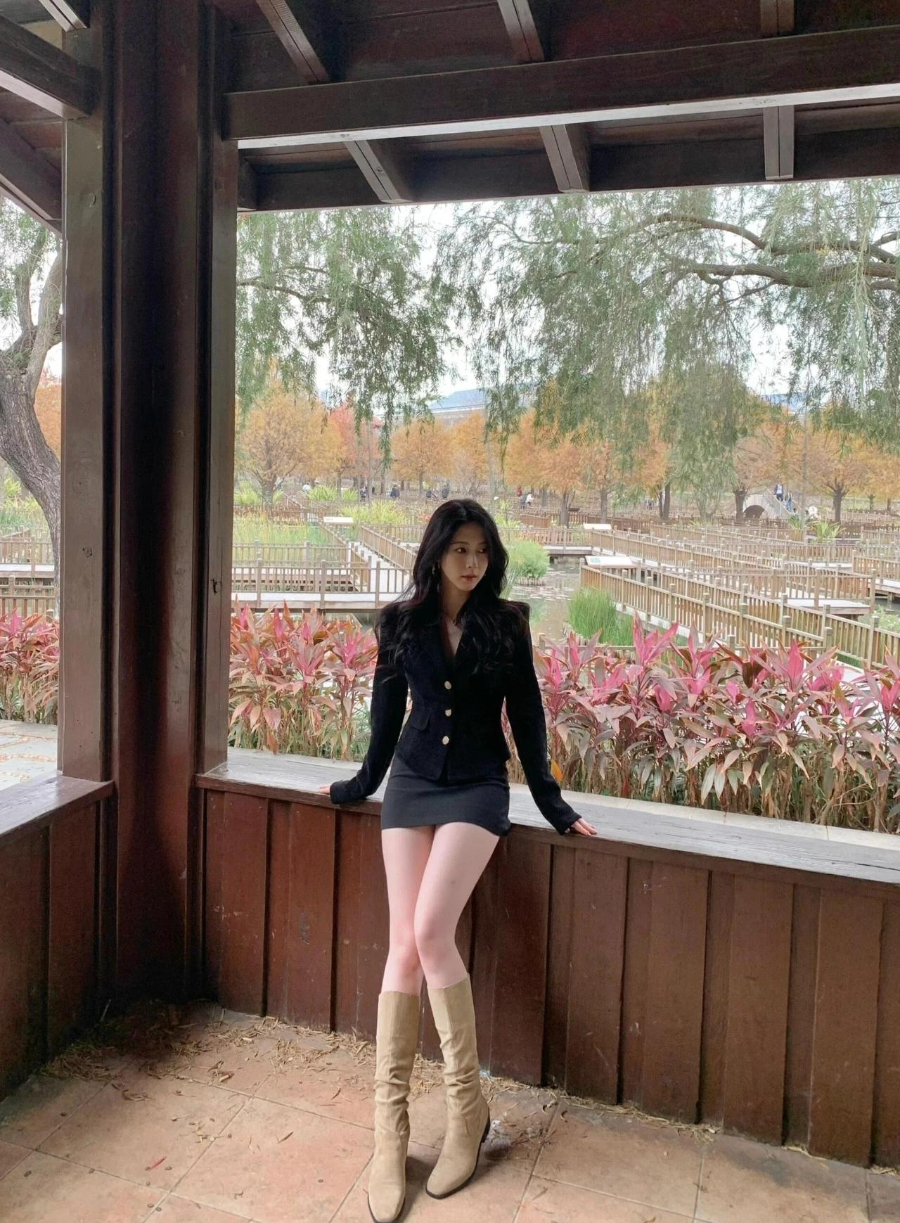 秋日公园里的时尚穿搭，黑西装与棕色靴子的完美搭配