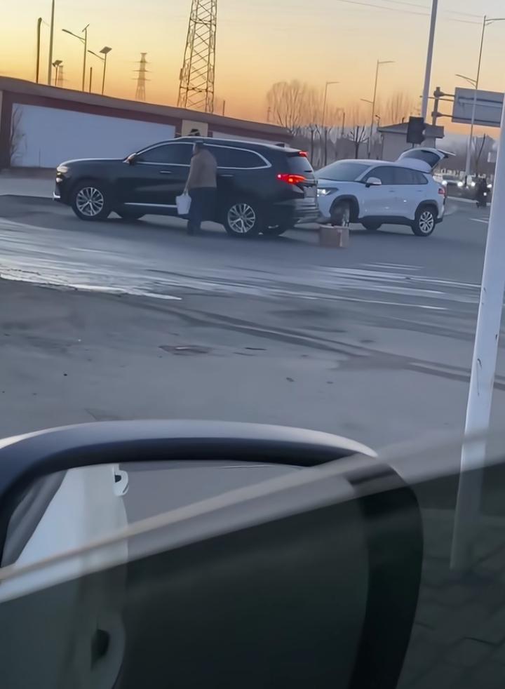 在加油站加油，无意中发现一白色汽车追赶黑色汽车，在加油站追上了，白色汽车车主下车