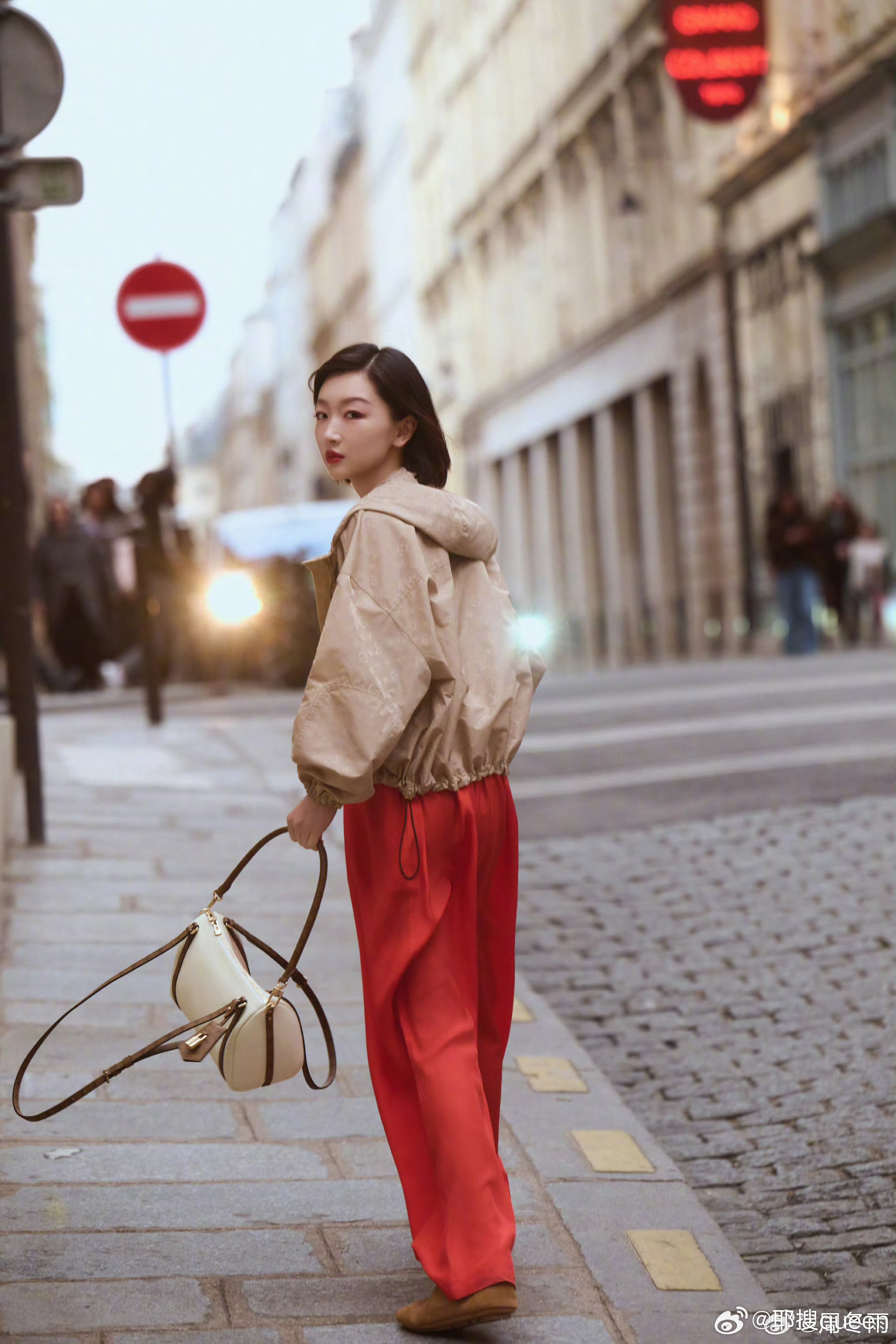 周冬雨漫步巴黎街头，卡其外套搭配红裤，随性又亮眼，每一帧都像电影画面，氛围感拉满