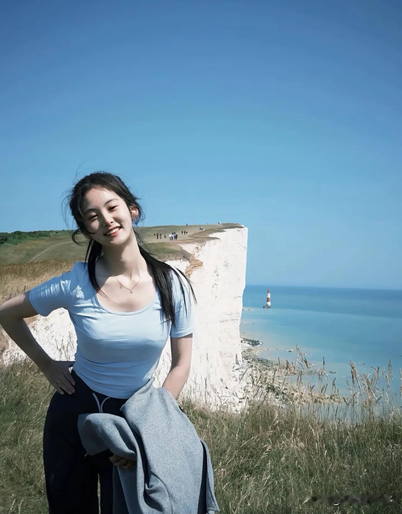 海风轻抚她的发梢，每一步都留下青春的印记。阳光洒在她微笑的脸庞，像一幅会呼